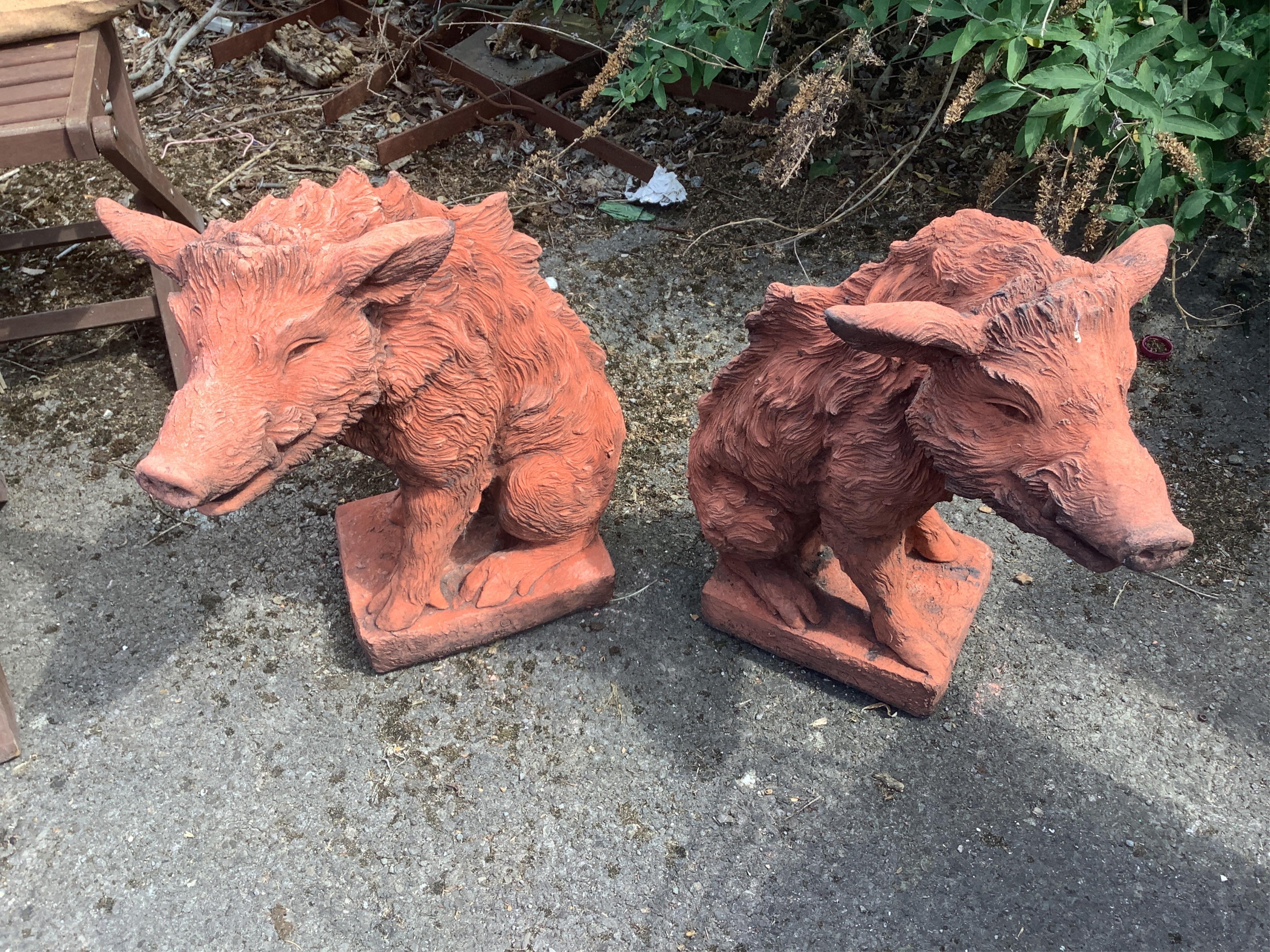 A pair of terracotta seated wild boar garden ornaments, height 55cm